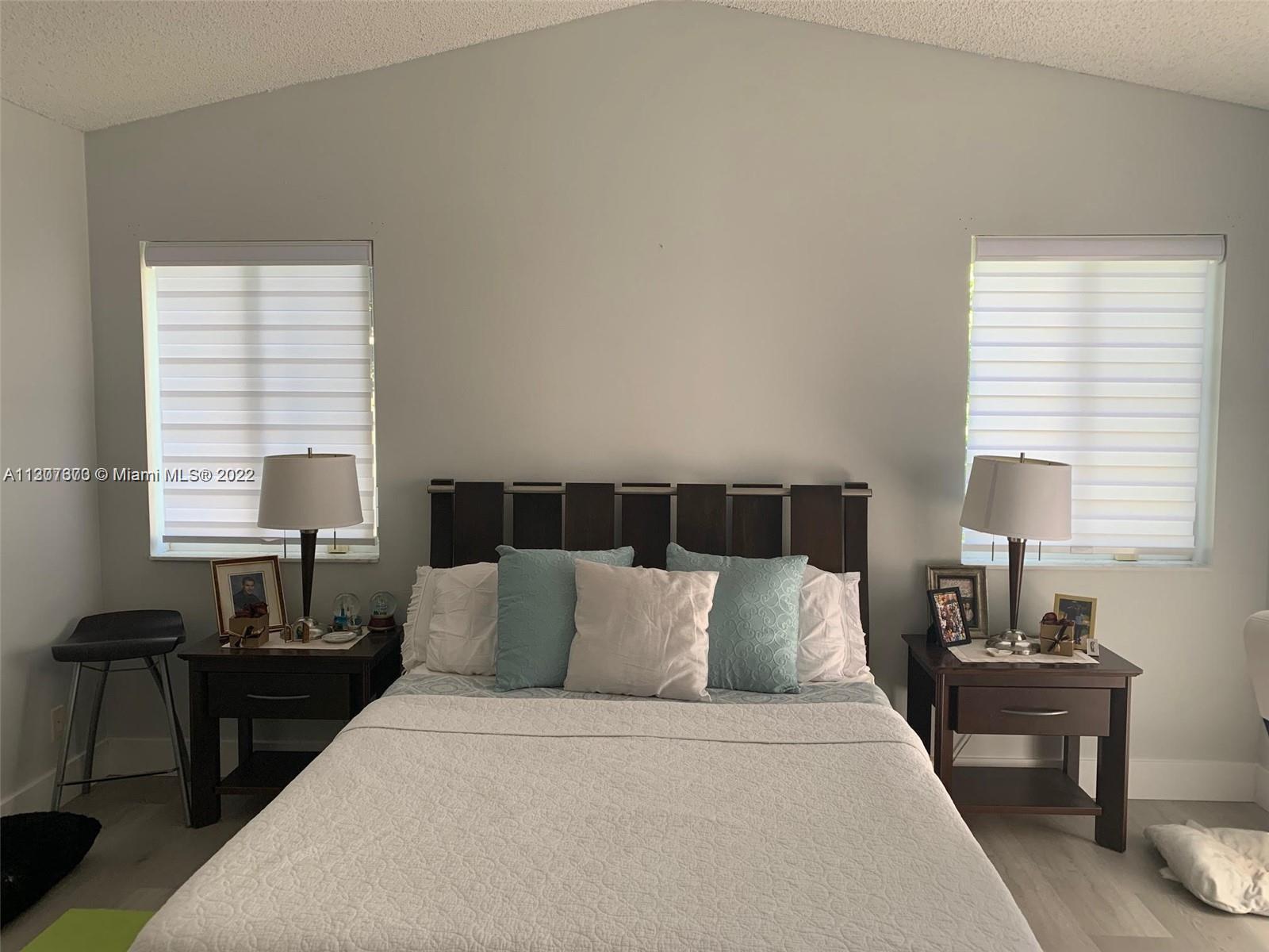 Savanna Weston, FL 33327 - Photo 17 of 24 a bedroom with bed and a lamp next to a window