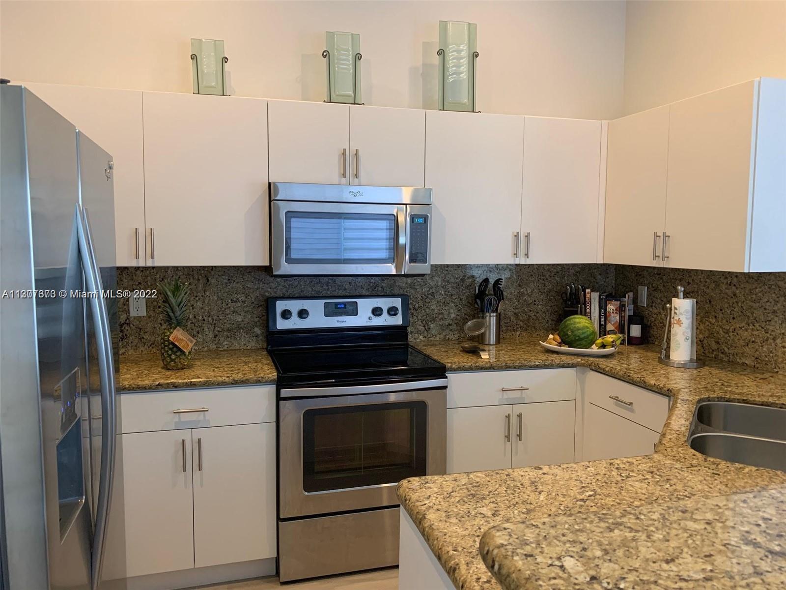 Savanna Weston, FL 33327 - Photo 4 of 24 a kitchen with granite countertop a sink stove and cabinets