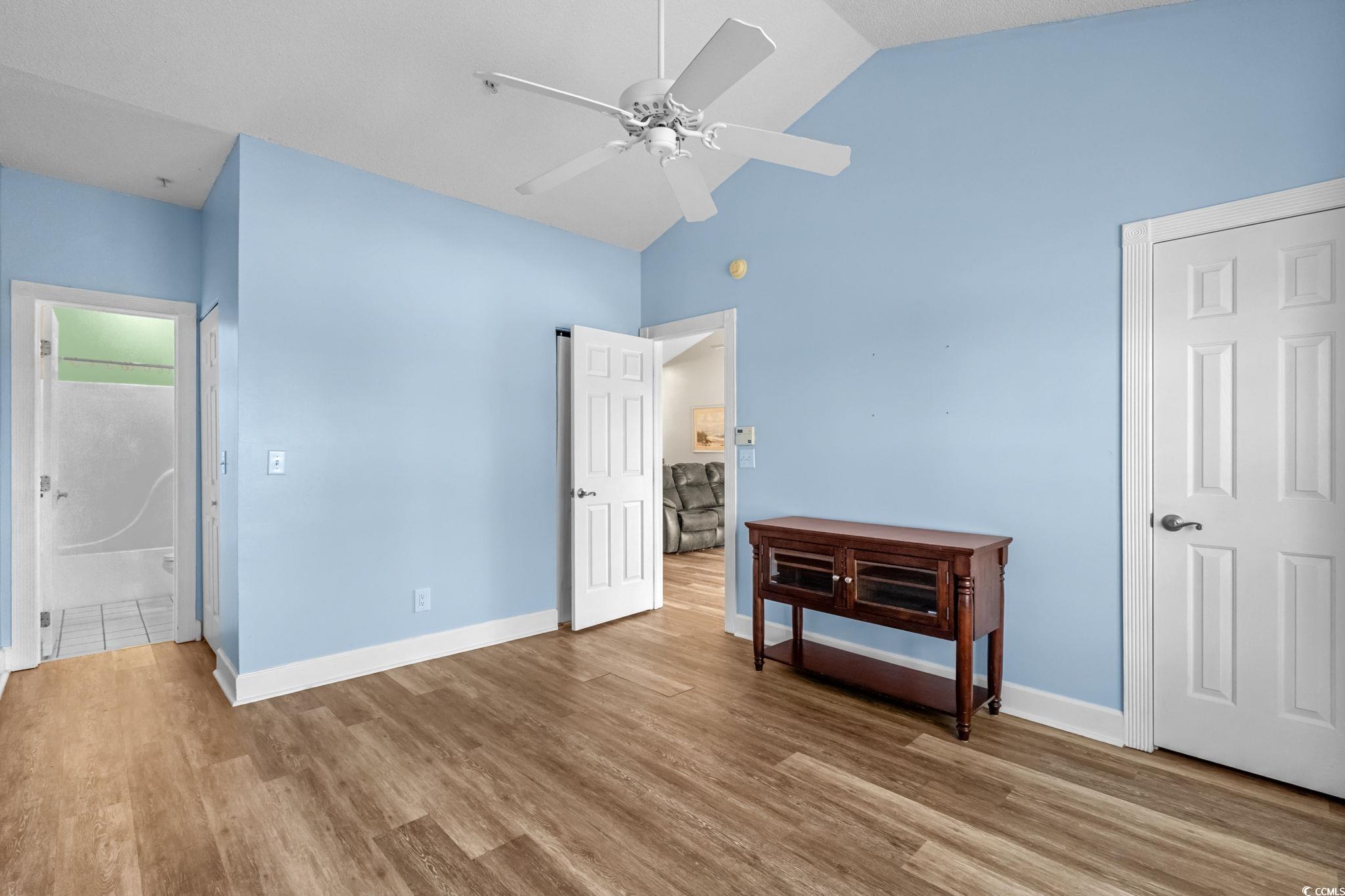 4815 Orchid Way, Unit 302 Myrtle Beach, SC 29577 - Photo 11 of 26 Bedroom with wood finished floors, ceiling fan, high vaulted ceiling, and ensuite bathroom