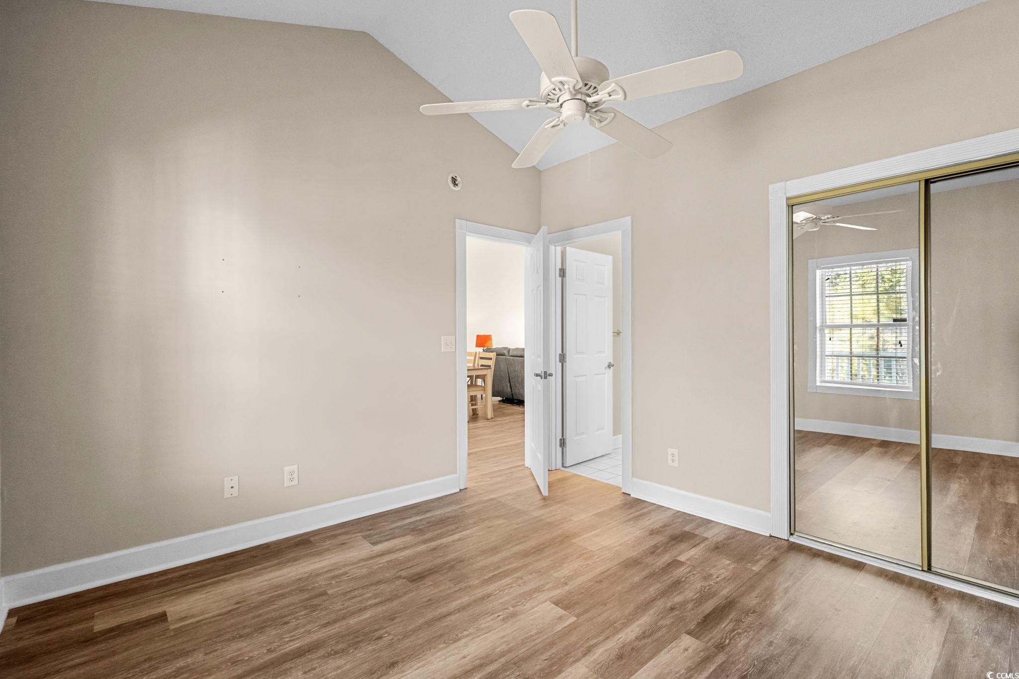 4815 Orchid Way, Unit 302 Myrtle Beach, SC 29577 - Photo 15 of 26 Unfurnished bedroom featuring vaulted ceiling, wood finished floors, a closet, and a ceiling fan