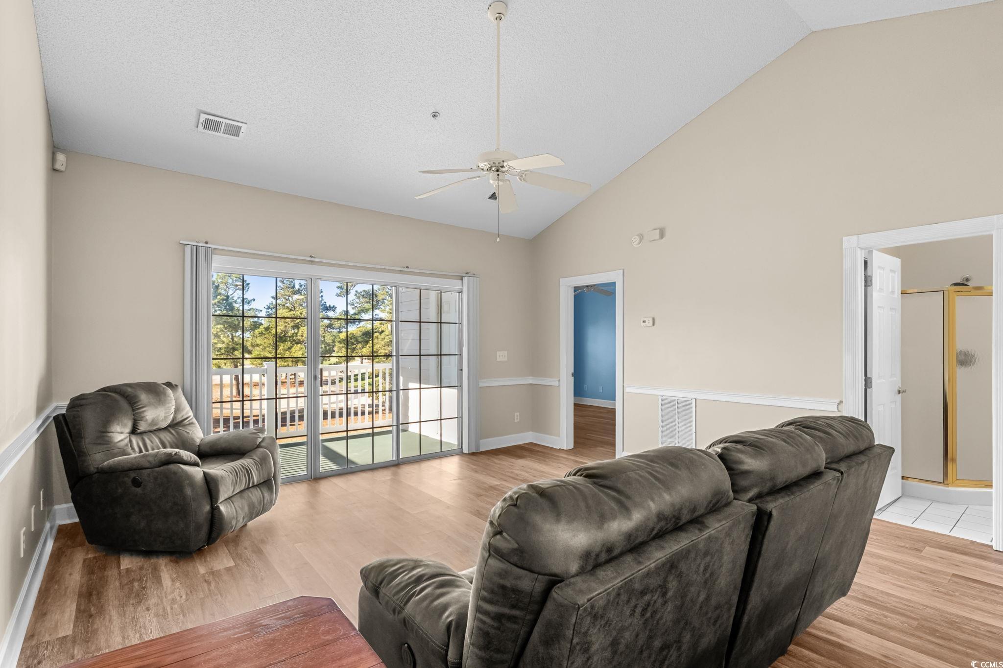 4815 Orchid Way, Unit 302 Myrtle Beach, SC 29577 - Photo 7 of 26 Living room featuring light wood-style flooring, high vaulted ceiling, a ceiling fan, and a textured ceiling