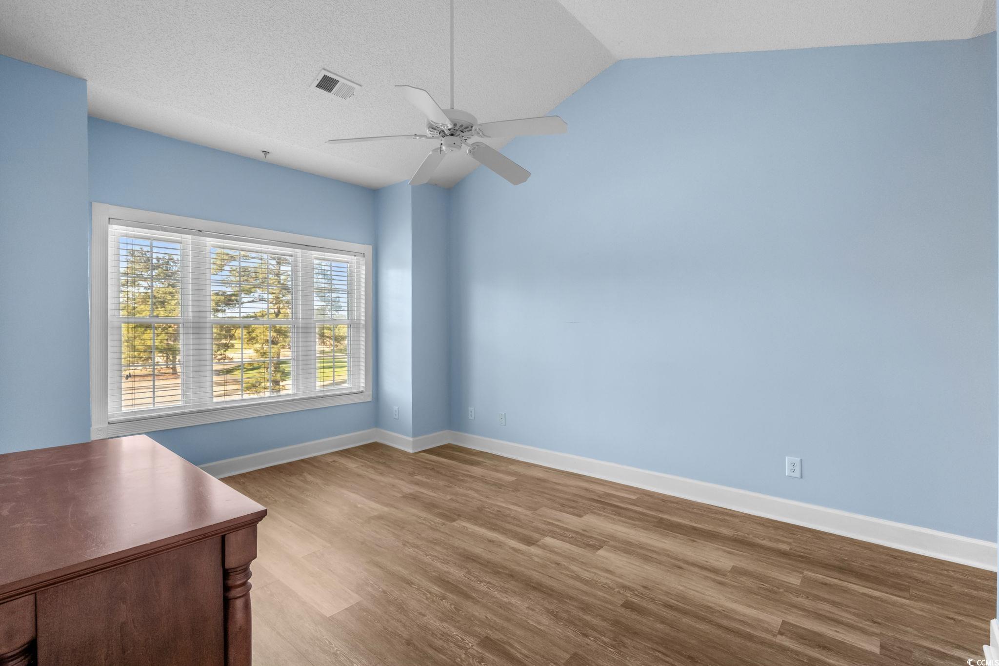4815 Orchid Way, Unit 302 Myrtle Beach, SC 29577 - Photo 9 of 26 Spare room with light wood-style floors, lofted ceiling, ceiling fan, and a textured ceiling