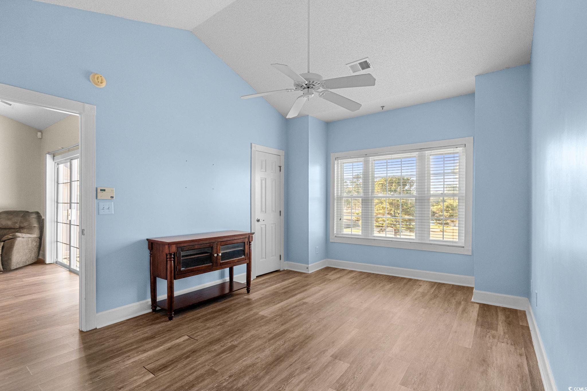 4815 Orchid Way, Unit 302 Myrtle Beach, SC 29577 - Photo 10 of 26 Spare room with light wood finished floors, lofted ceiling, ceiling fan, and a textured ceiling