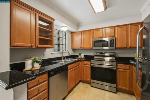 a kitchen with stainless steel appliances granite countertop a sink stove and microwave