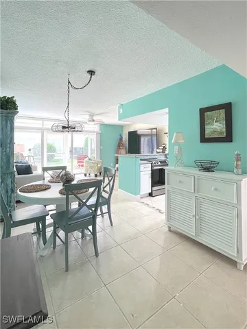a view of a dining room and livingroom with furniture wooden floor a rug a painting and a chandelier
