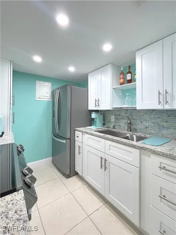 a kitchen with a refrigerator sink and cabinets
