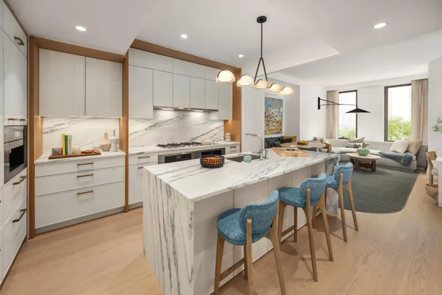 a kitchen with stainless steel appliances granite countertop a stove and white cabinets with wooden floor