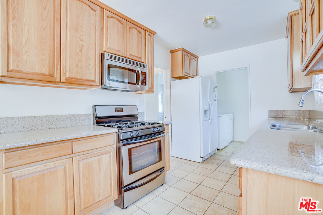 6919 Vanalden Avenue Reseda, CA 91335 - Photo 5 of 10 a kitchen with stainless steel appliances granite countertop a stove and a sink