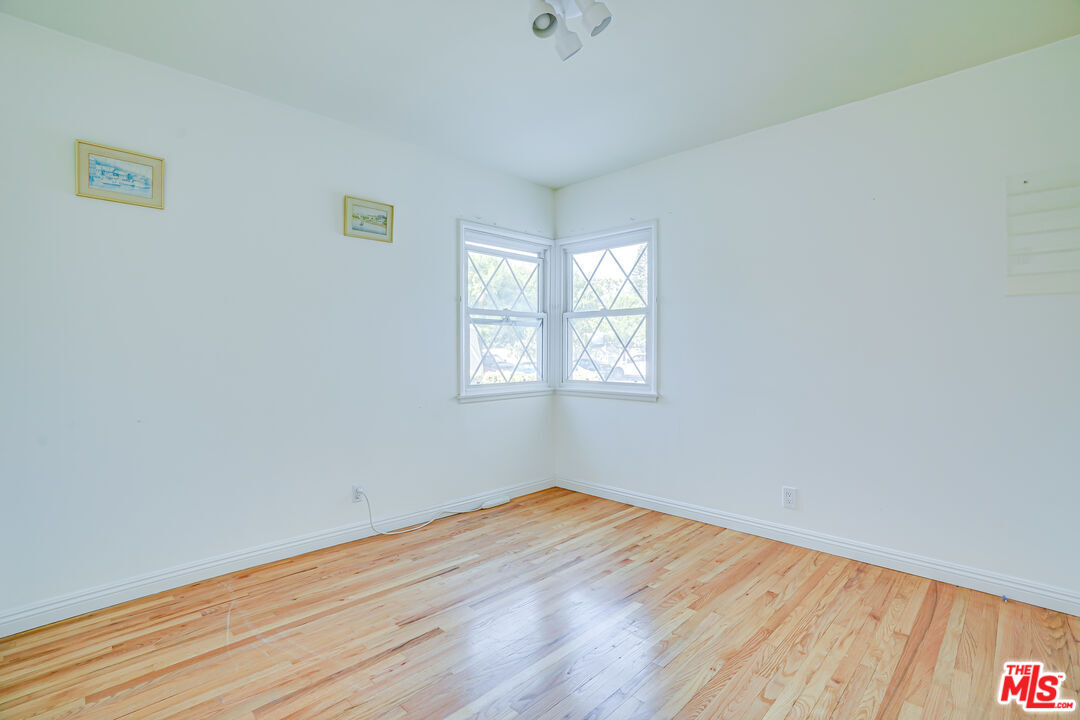 6919 Vanalden Avenue Reseda, CA 91335 - Photo 6 of 10 an empty room with wooden floor and windows