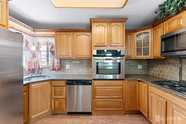 a kitchen with stainless steel appliances granite countertop a stove a sink and a microwave
