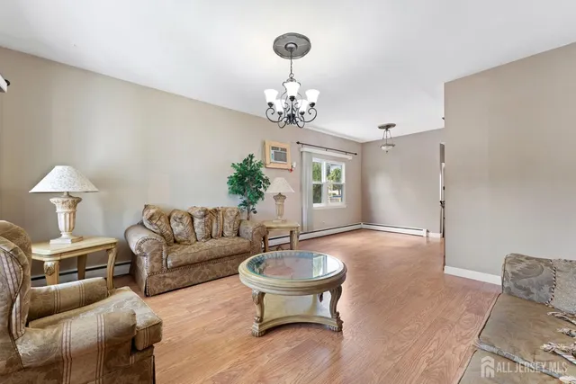 a living room with furniture a chandelier and a window