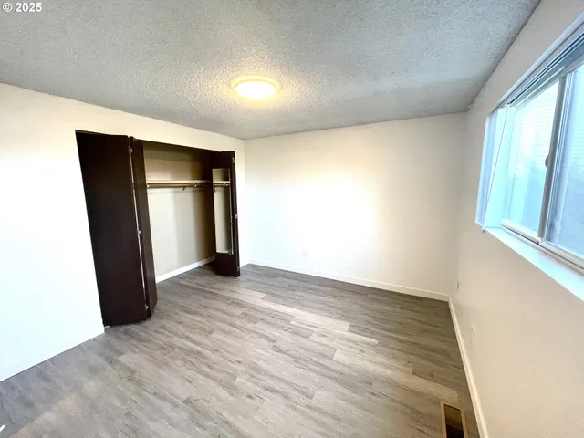 an empty room with closet and wooden floor