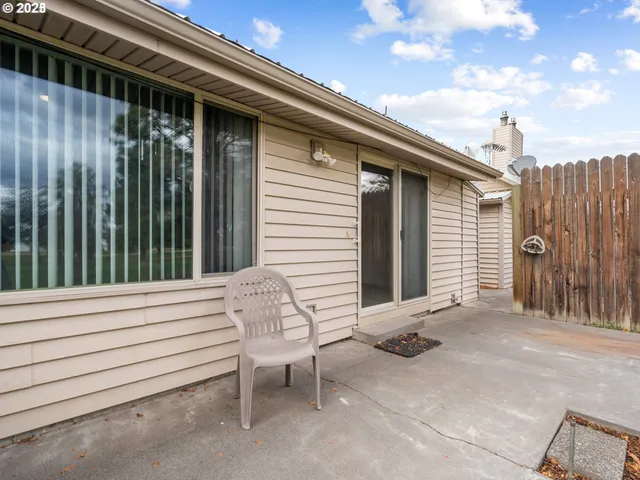 a view of a chair and table in the back yard of the house