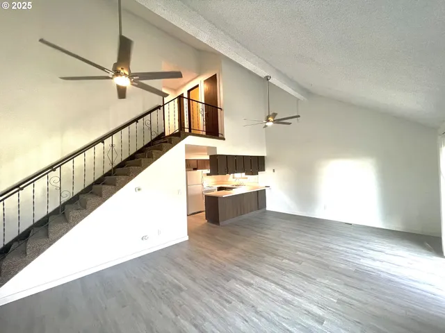a view of a kitchen with wooden floor and electronic appliances