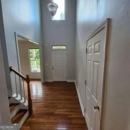 a view of a hallway with wooden floor and stairs