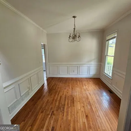 a view of empty room with wooden floor and window