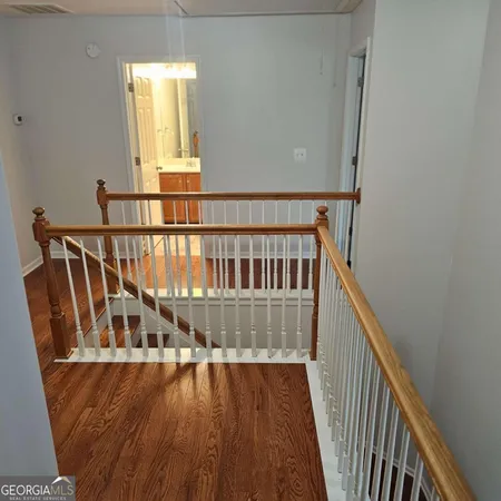 a view of a hallway with wooden floor and staircase