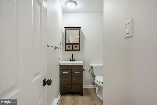 a bathroom with a granite countertop toilet a sink and a mirror