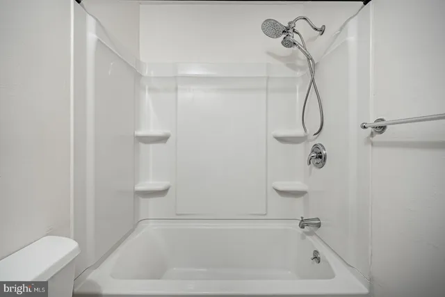 a bathroom with a bath tub with a shower