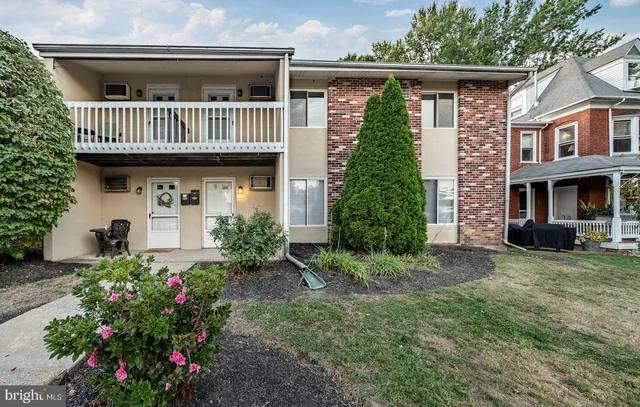 a view of a house with a small yard and flower plants