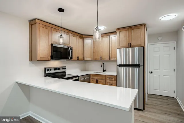 a kitchen with stainless steel appliances a refrigerator sink and microwave