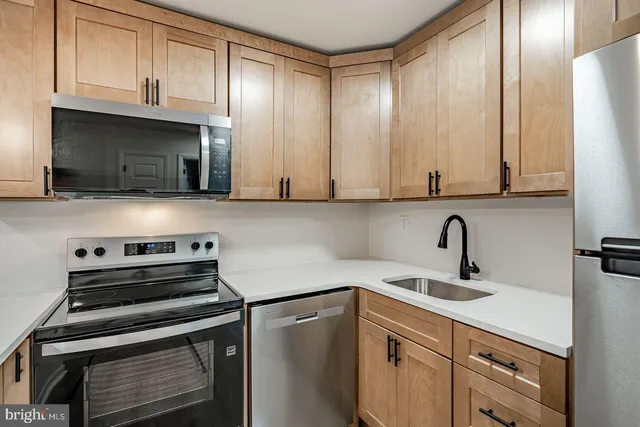 a kitchen with stainless steel appliances a stove a sink and cabinets