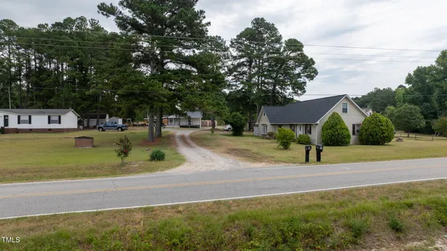 a view of a house with a yard and sitting area