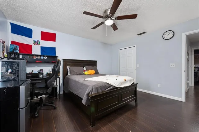 a bedroom with a bed a dresser and wooden floor