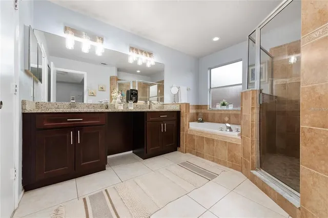 a large bathroom with a granite countertop double vanity sink and mirror