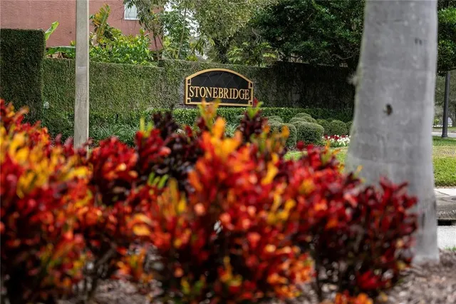 a sign that is sitting in front of a tree