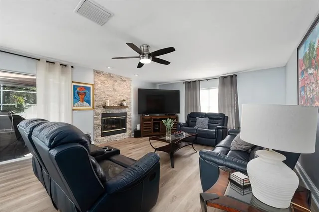 a living room with furniture ceiling fan and a window