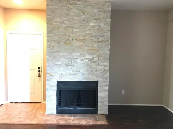 a view of an empty room with a fireplace and a window