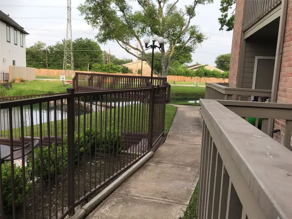 a view of an empty room with wooden floor and a fireplace