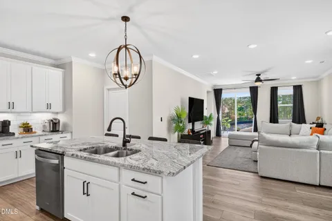 a kitchen with granite countertop a table chairs stove and refrigerator