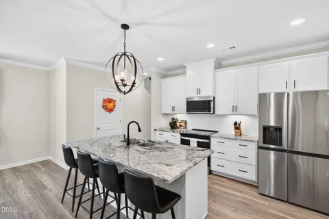 a kitchen with granite countertop stainless steel appliances a refrigerator a sink a counter space and cabinets