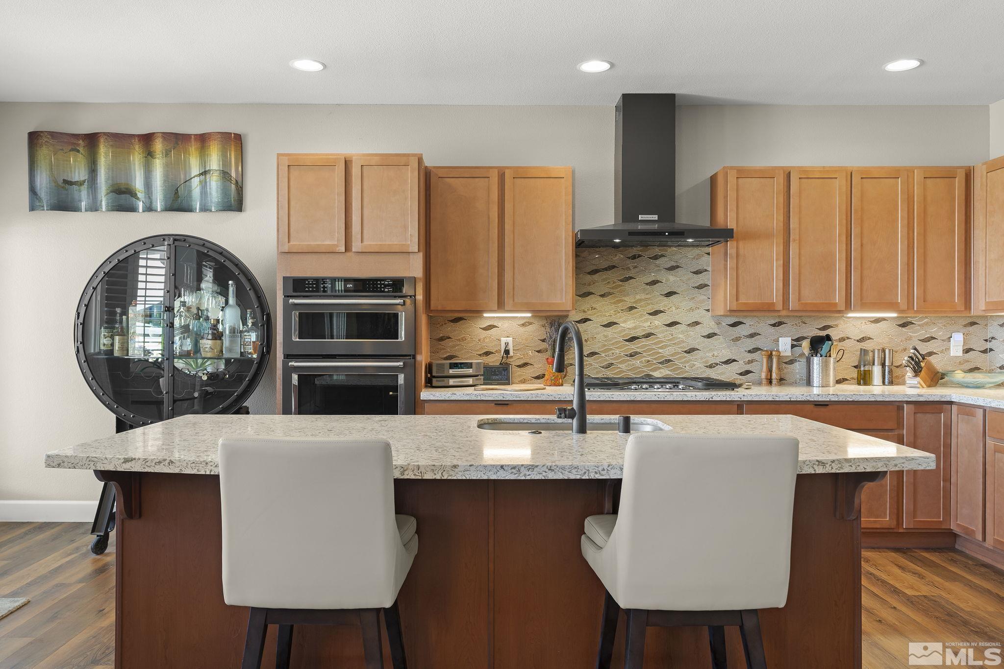 2239 Windflower Drive Reno, NV 89521 - Photo 12 of 40 a kitchen with stainless steel appliances a dining table chairs microwave and sink