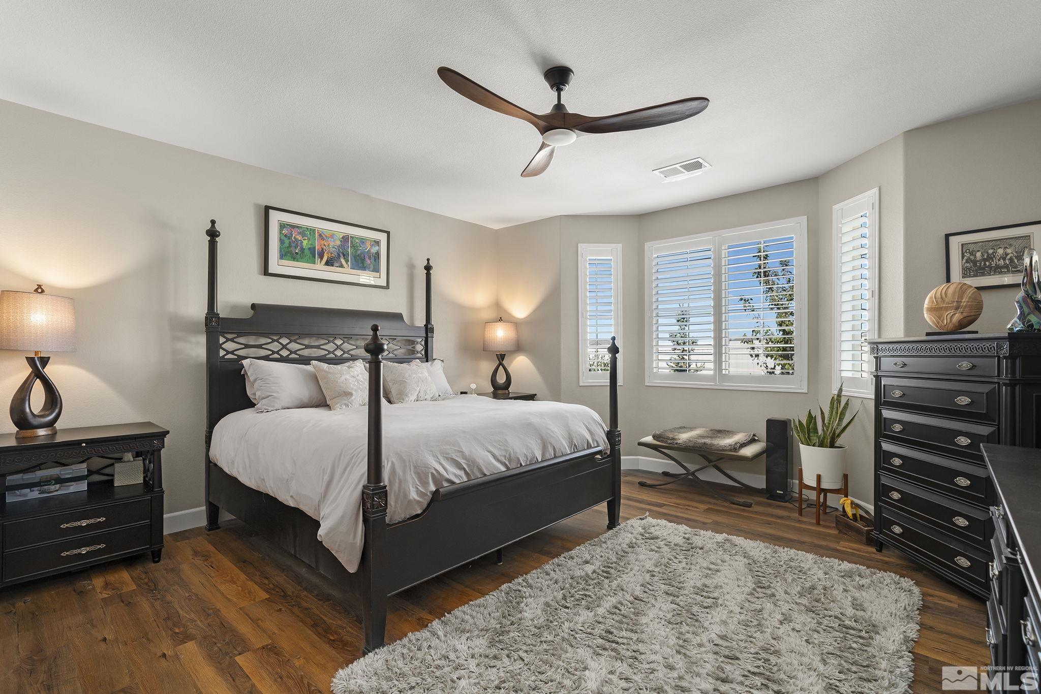 2239 Windflower Drive Reno, NV 89521 - Photo 20 of 40 a bedroom with a bed and a chandelier