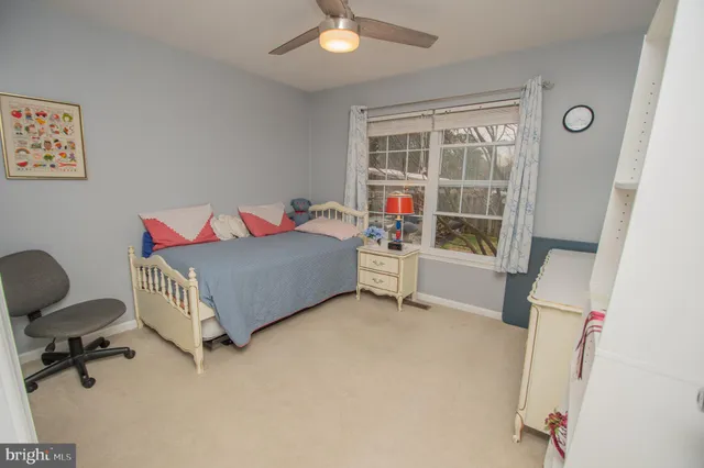 a living room with baby crib furniture a chandelier and a window