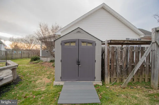 a view of a house with backyard and wooden fence