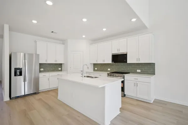a kitchen with a stove a sink and a refrigerator