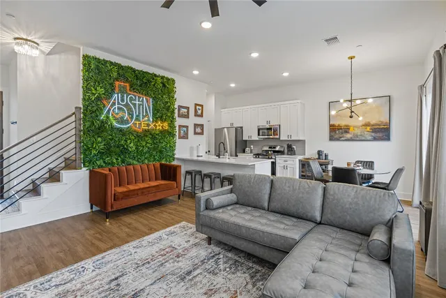 a living room with furniture a chandelier and kitchen view
