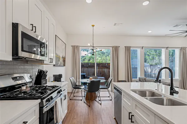 a kitchen with stainless steel appliances a stove sink microwave and cabinets