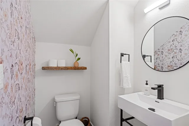 a bathroom with a toilet sink and mirror