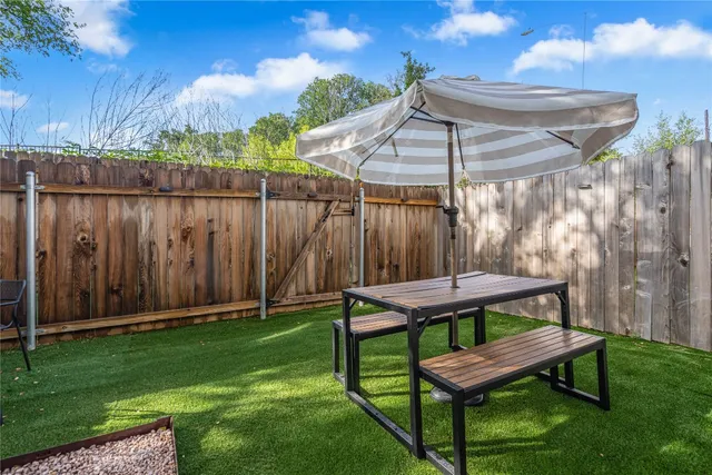 a view of a backyard with wooden fence and a bench