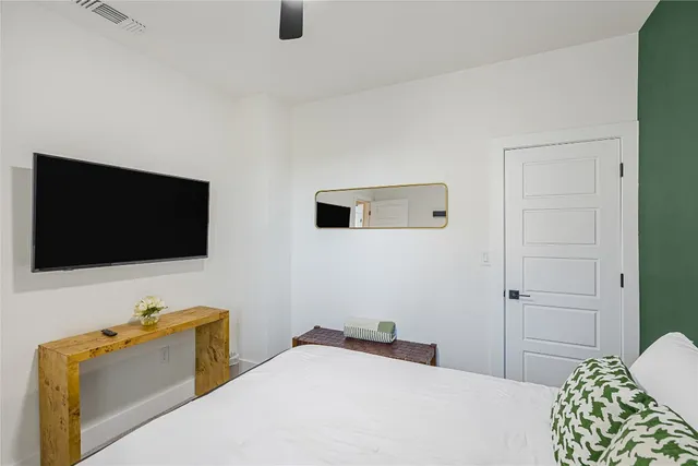 a bedroom with a bed a couch and a large mirror