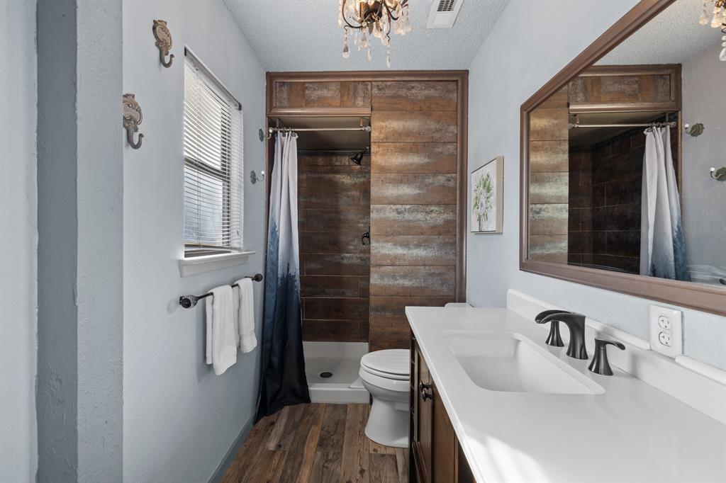 3708 Windsong Lane Bedford, TX 76021 - Photo 23 of 35 a bathroom with a sink a toilet and shower