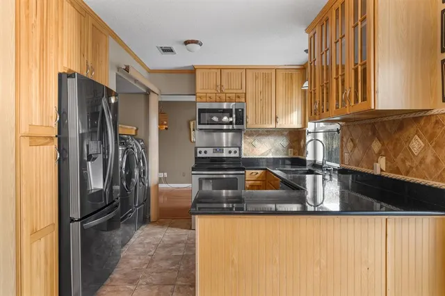 a kitchen with granite countertop a refrigerator and a sink