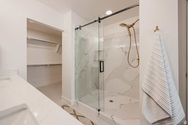 5902 Canyon Rim Road, Unit 620 Lehi, UT 84048 - Photo 51 of 78 Walk-in shower featuring a glass enclosure with matte black hardware, marble-look tile surround, and brushed gold fixtures