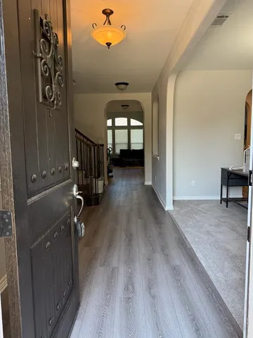 a view of a hallway with wooden floor and stairs