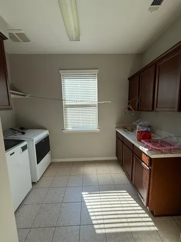 a large kitchen with a large counter top cabinets and stainless steel appliances